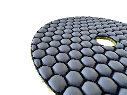 Close-up of 100 grit honeycomb polishing pad showing resin bond surface for controlled concrete polishing