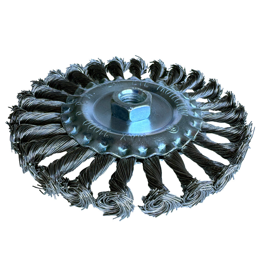 Knotted wire wheel brush removing rust and weld residue from metal surfaces using an angle grinder